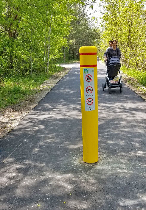 couple pushing a baby stroller on a paved trail